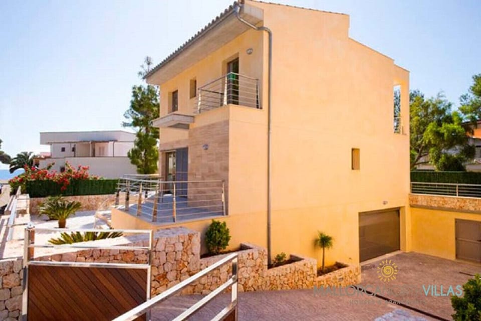 Vista exterior diurna de Villa Mediterranean, moderna villa con terrazas, balcones y acceso privado en zona residencial tranquila.