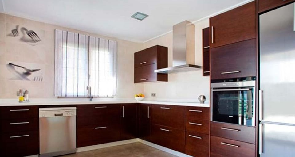 Modern fully equipped kitchen of Villa Mediterranean with oven, dishwasher, fridge and generous workspace.