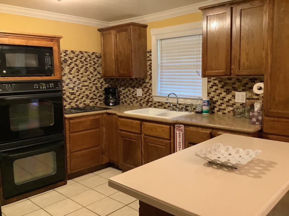 Modern kitchen with amenities: gas stovetop, toaster, coffee pot, and kettle 