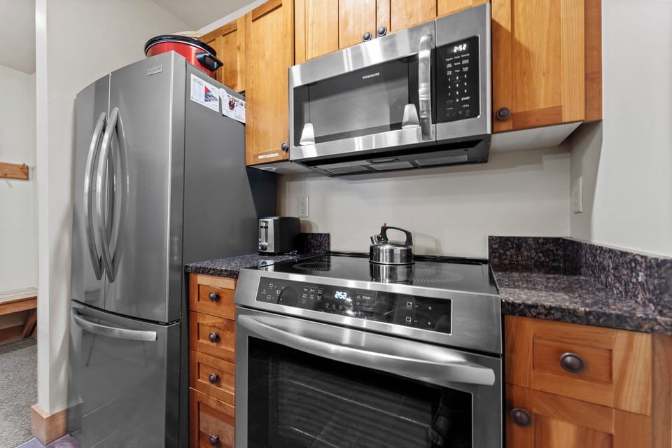 Your fully equipped kitchen features stainless steel appliances and warm wood cabinets, perfect for preparing meals during your stay.