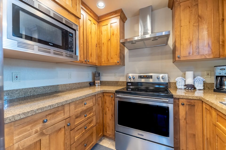 Your fully equipped kitchen features warm wood cabinets, granite counters, stainless steel appliances, and everything you need to create memorable meals.