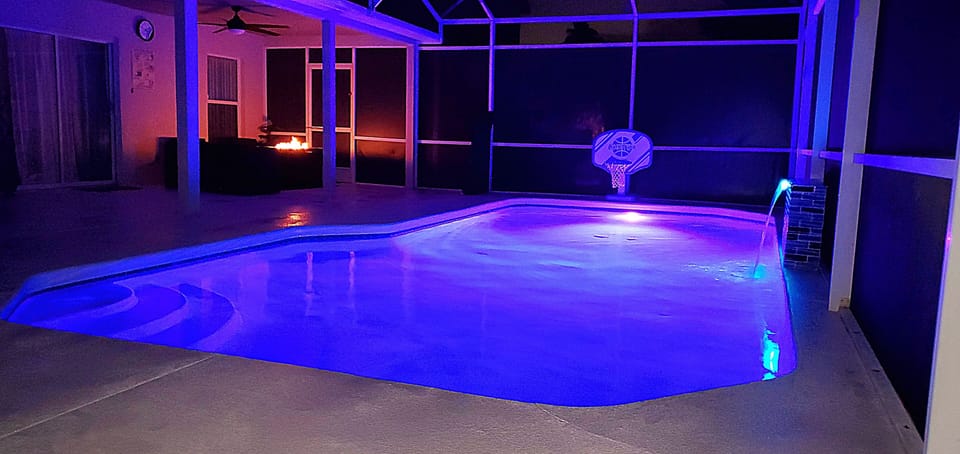 The villa's swimming pool presents a captivating nighttime scene.