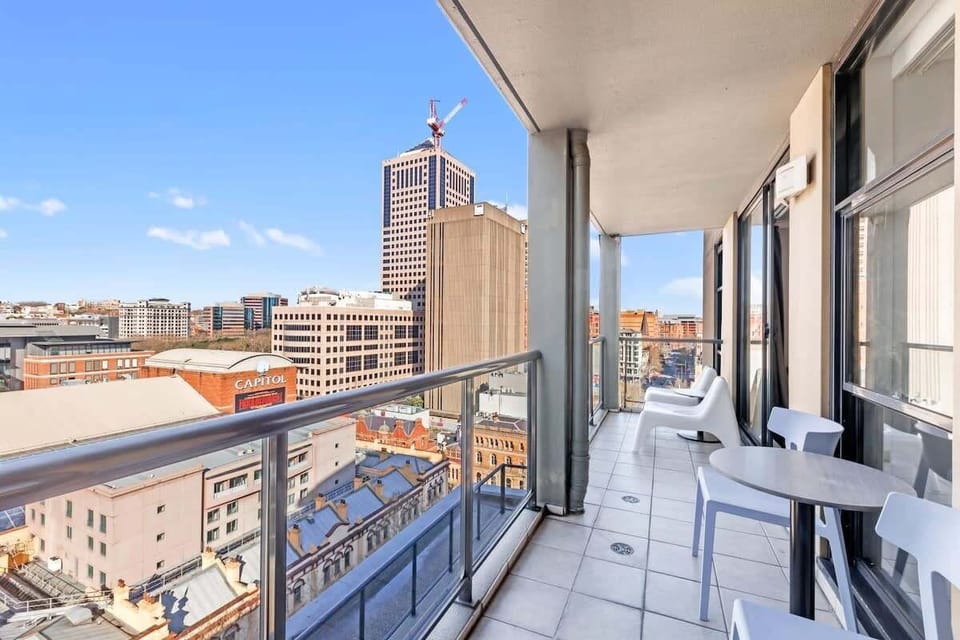 Balcony with outdoor seating and elevated city outlook.