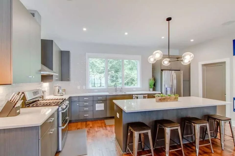 Kitchen w/ fridge, freezer, dishwasher, microwave, gas range, and double oven.