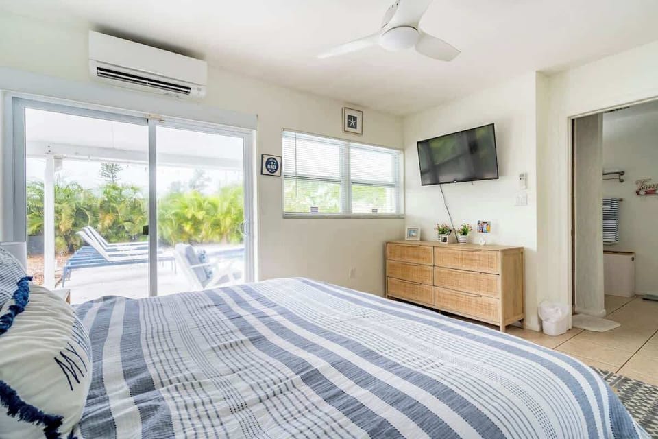 Master bedroom with king bed, master bath to the right.  Sliding door to the pool area.
