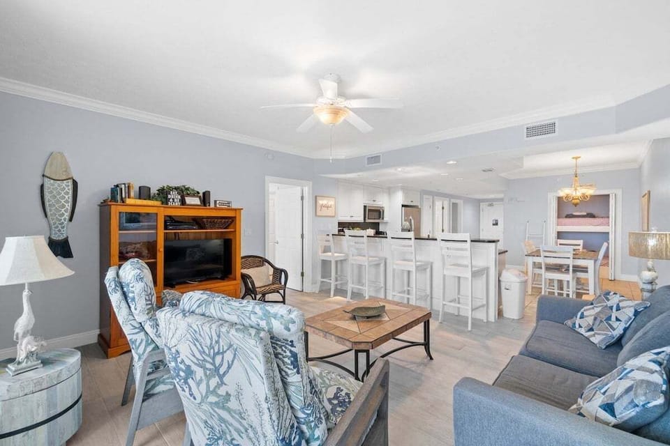 The living room offers an inviting coastal feel with plenty of comfortable seating, perfect for relaxing after a day on the beach.