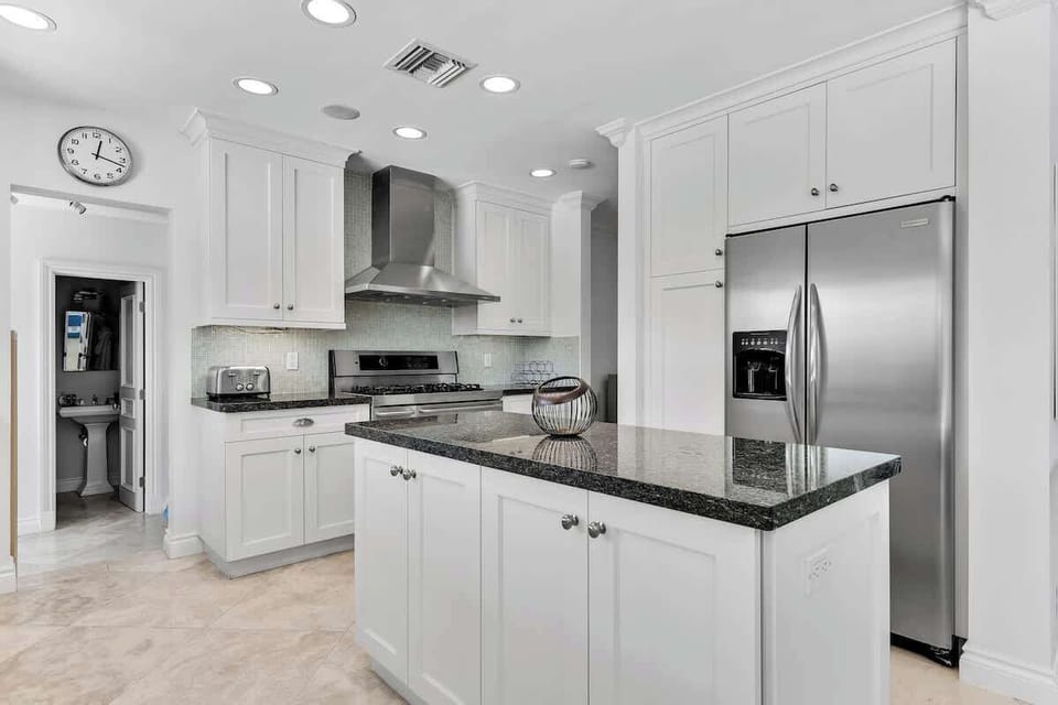 Modern kitchen with sleek finishes—perfect for vacation rentals and short-term stays. Enjoy stainless steel appliances, granite countertops, and a clean design ideal for cooking, entertaining, and relaxing getaways.