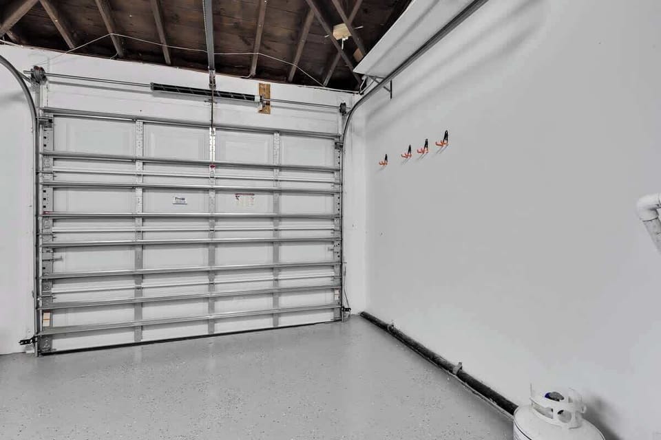Spacious garage with epoxy flooring—perfect for vacation rentals and short-term stays. Enjoy clean design, tool storage, and secure parking ideal for road trips, extended stays, or family getaways.