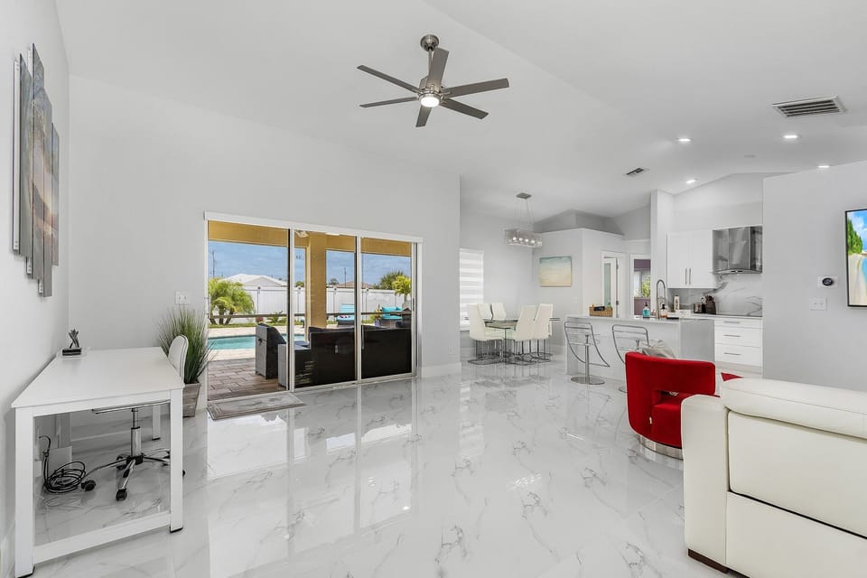 Open living area with premium Italian furniture, office corner, modern kitchen.