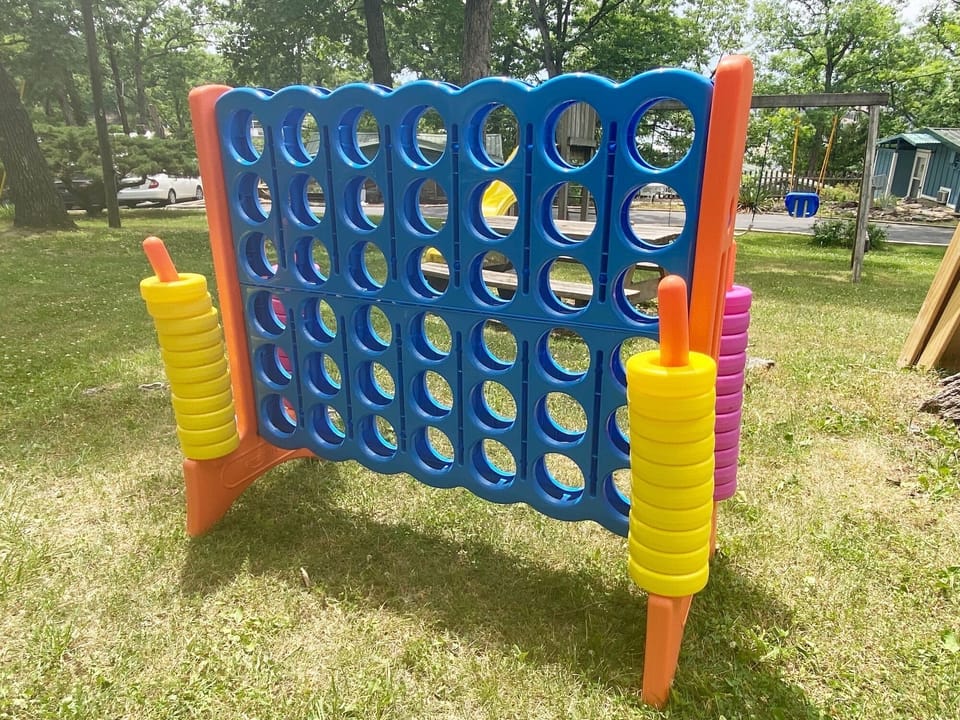 The adults can enjoy a game of Giant Connect 4 while the kids are at the playground.