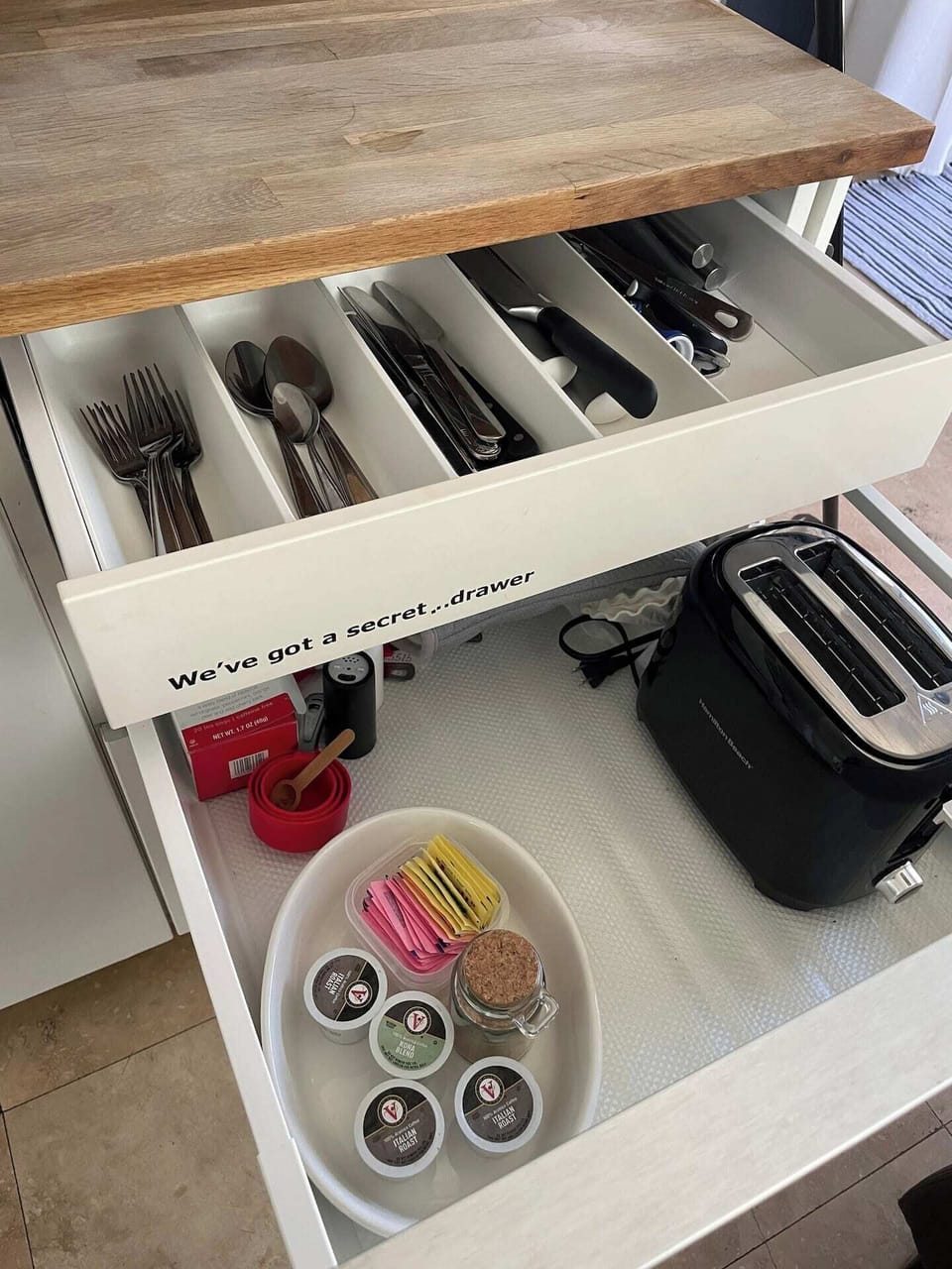 Utensils inside secret drawer under kitchen countertop