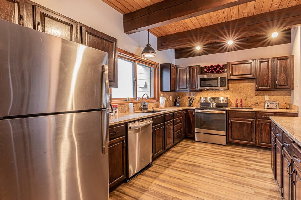 fully equipped kitchen featuring sleek stainless steel appliances and ample granite-style counter space.