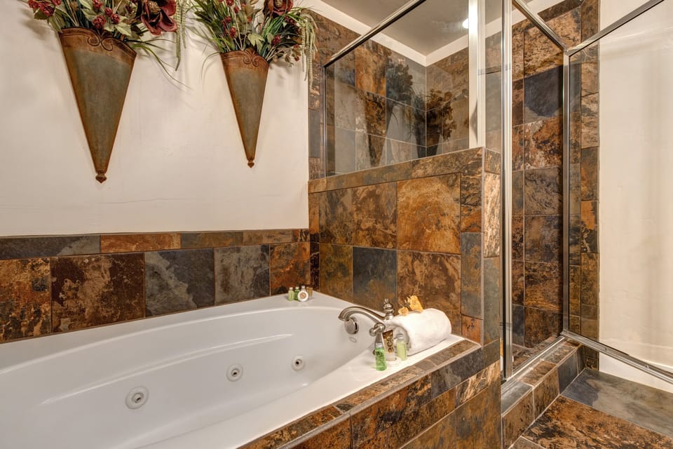 Master Bathroom with double sinks, jetted tub, and tile & glass shower