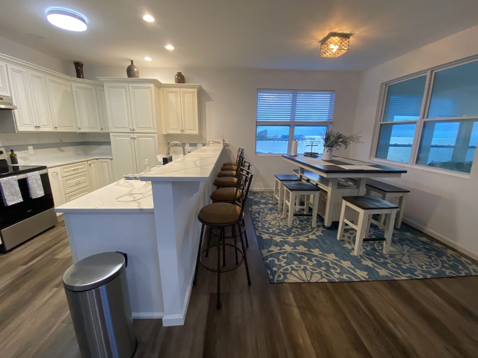 View of fully equipped kitchen and table - can accommodate all of our guests!