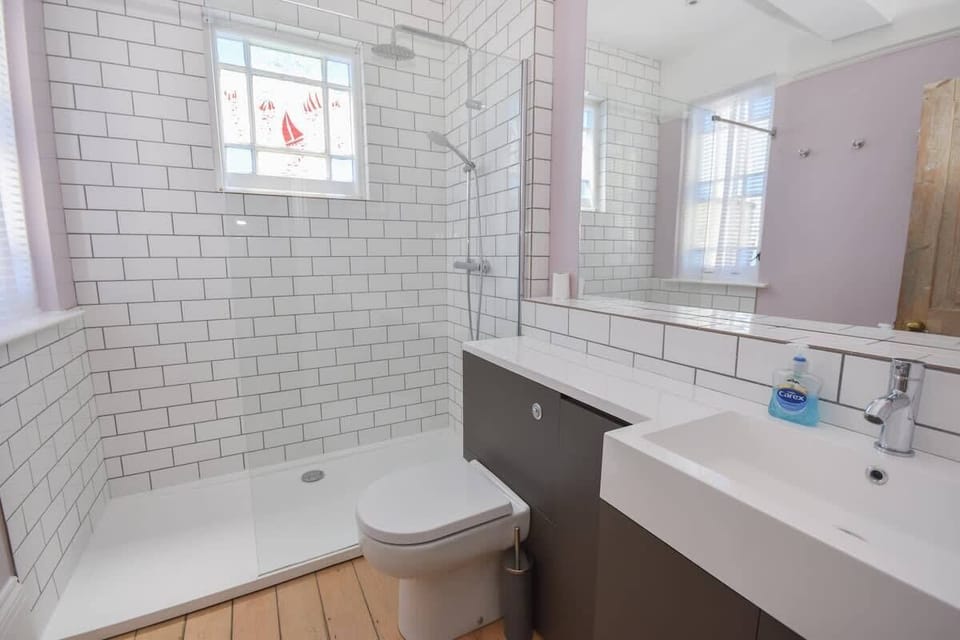 The main family shower room features a large walk-in glass cubicle and contemporary finishes.