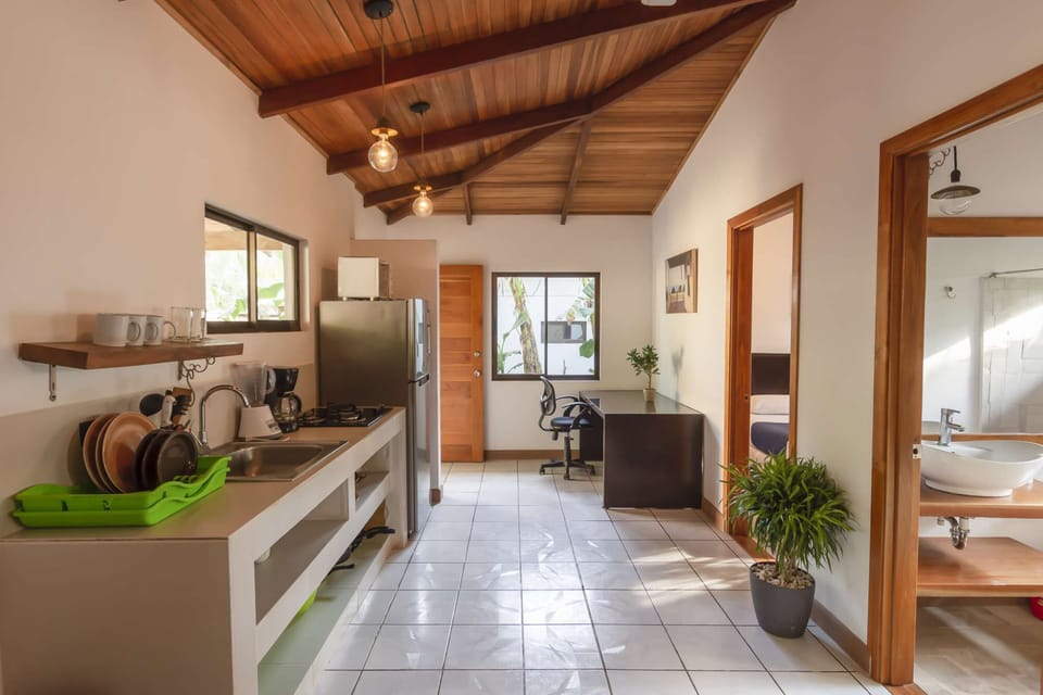 The spacious interior layout of the kitchen, bathroom, a bedroom, and work space, with the patio to the left