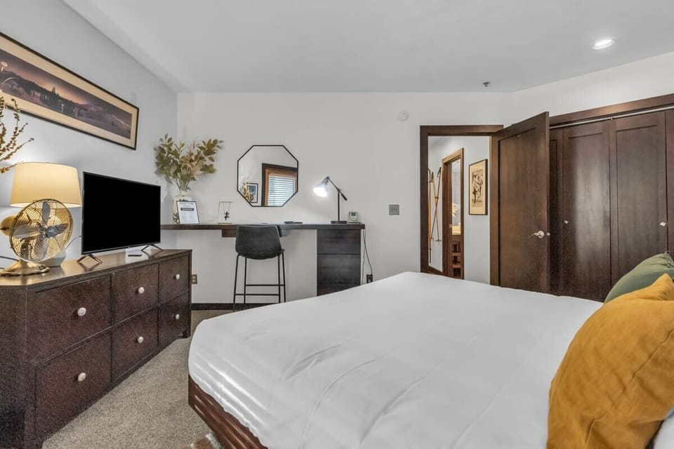 The beautiful bedroom features a king-size bed, flat-screen TV, desk area, dresser, nightstands, lamps and access to the private patio space with a hot tub.