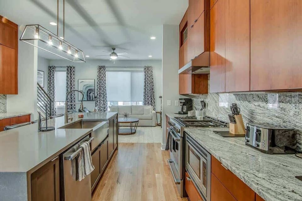 Cook and clean with ease in this spacious kitchen featuring a large island, built-in sink, and dishwasher for added convenience.