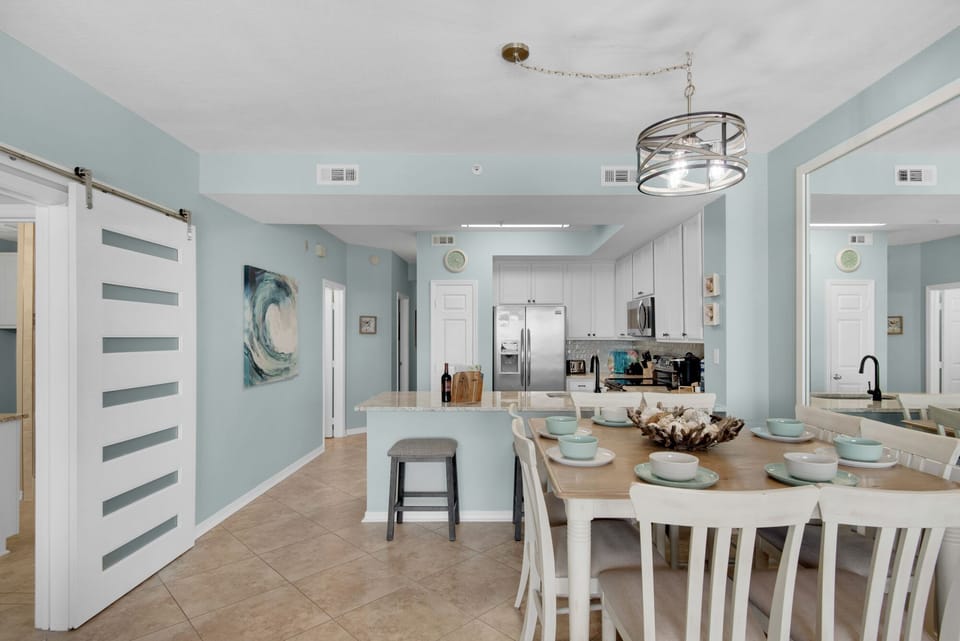 Step into your bright, coastal-inspired kitchen and dining space where ocean blues meet crisp whites, creating the perfect backdrop for memorable meals.