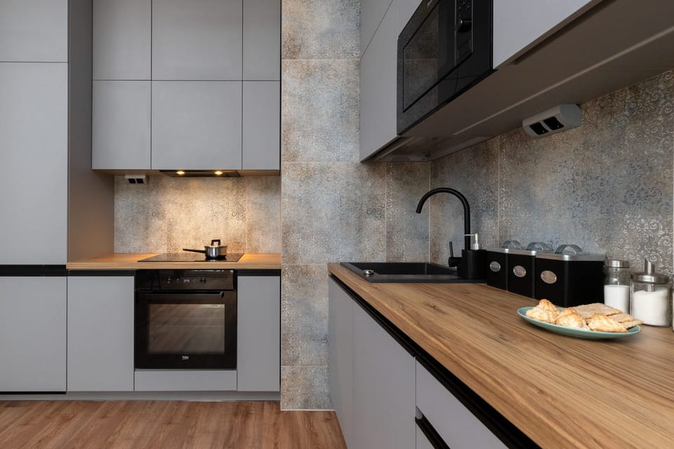 A sleek, modern kitchen with high-end appliances and a minimalistic gray and wood color scheme.