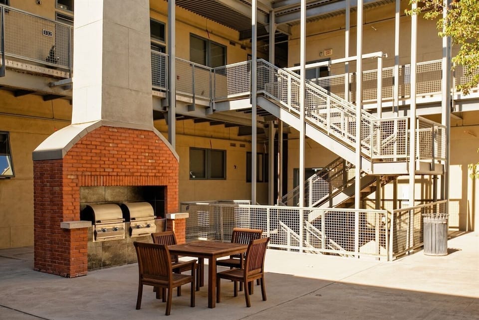 The condo complex boasts a center entertainment area with seating, a fireplace, and BBQ grills.