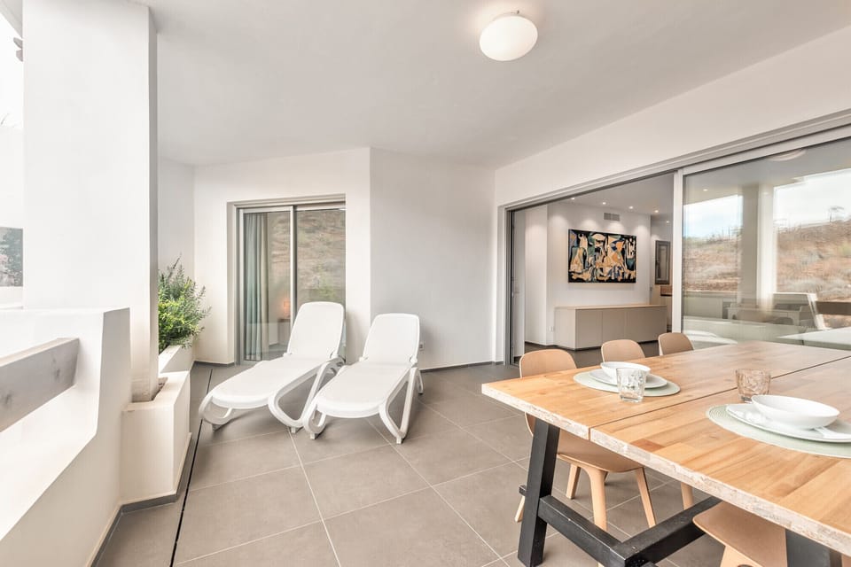 Large terrace with dining table and sunbathing area