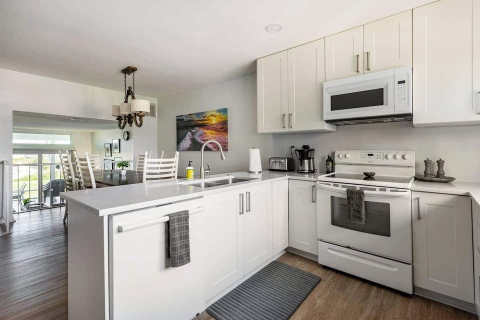 The kitchen is fitted with quartz countertops, shaker cabinets and full sized appliances.