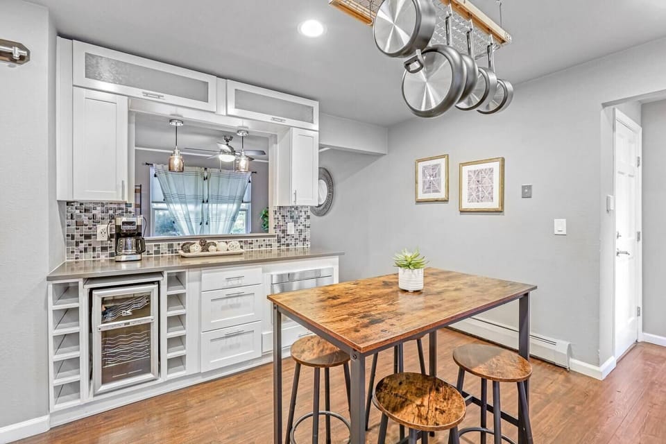 Nearby is a full dining set with plenty of chairs and additional seating at the kitchen island. 