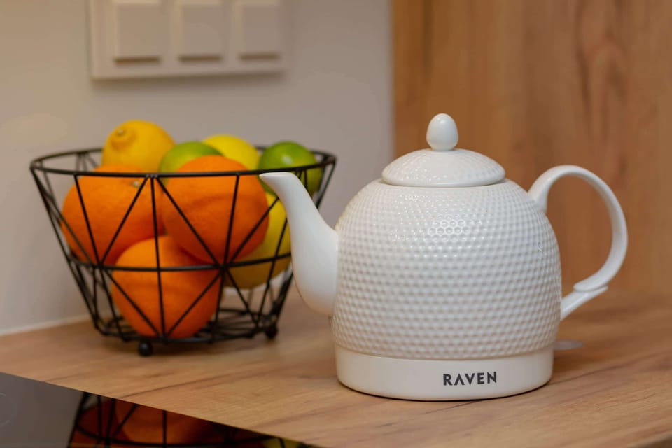 Close up of electric white kettle and fruit bowl.