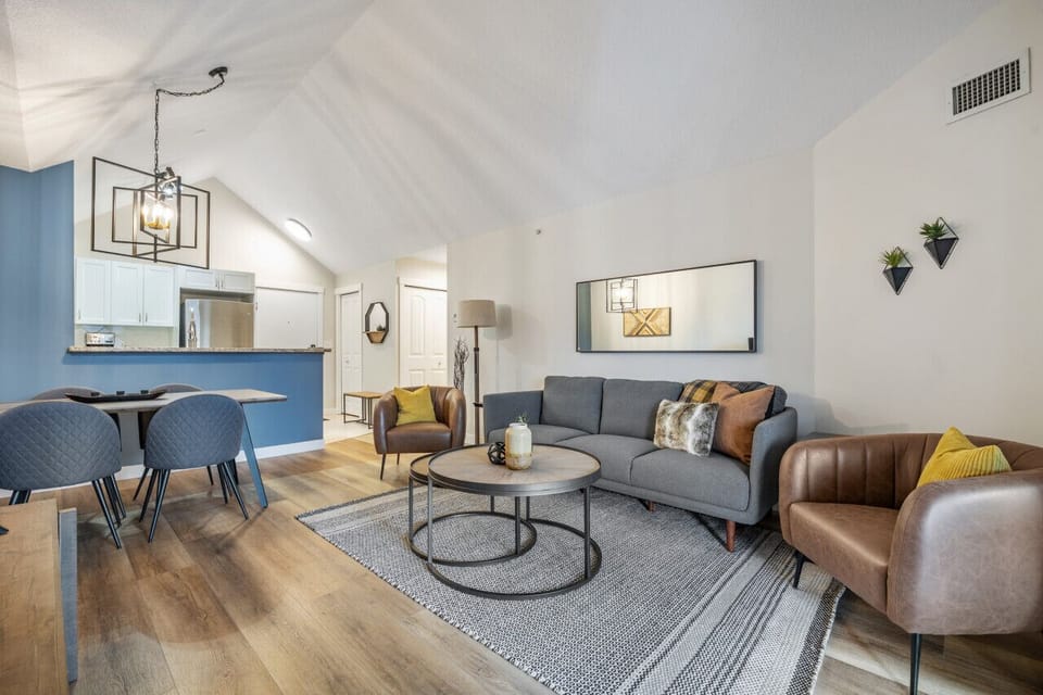 Living room with a large Smart TV, cozy seating options and access to the private balcony.