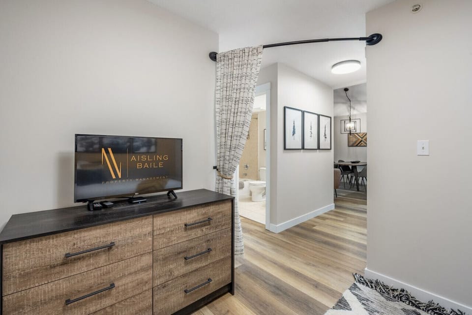 Den/third bedroom with a twin daybed, dresser and a Smart TV.
