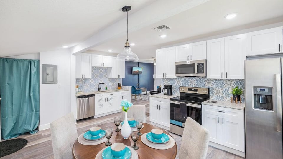 This kitchen features functional cabinets that provide ample storage space for your kitchen essentials and appliances. Additionally, the same space includes a dining area with seating for four.