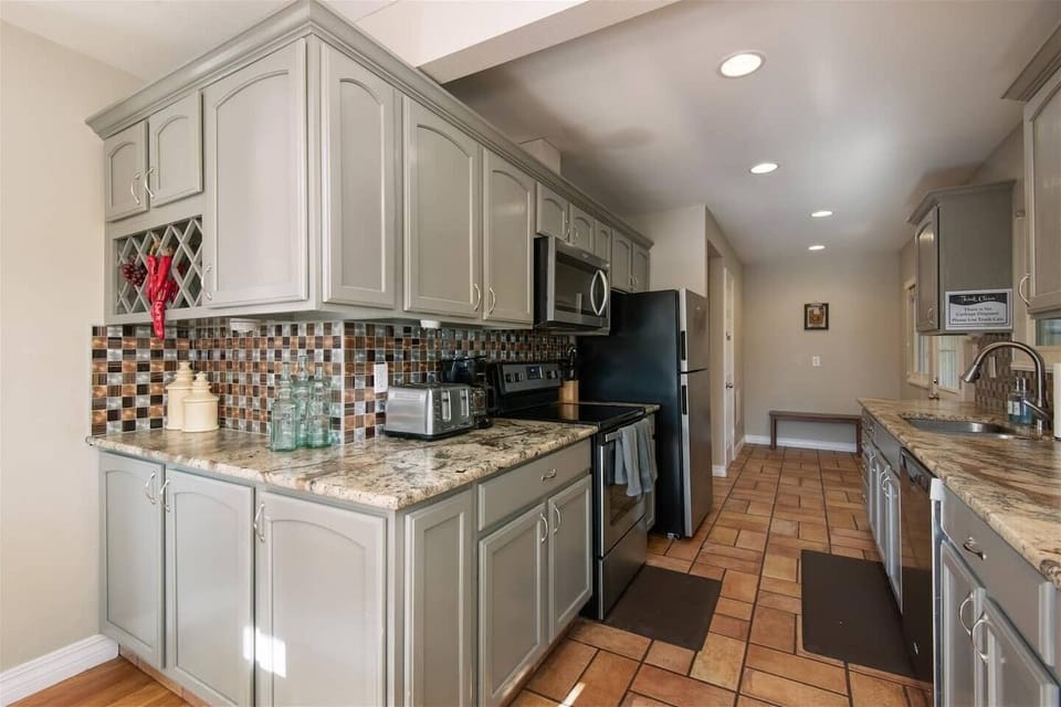 The kitchen includes a stainless steel refrigerator, stove, oven, microwave and coffee maker. 