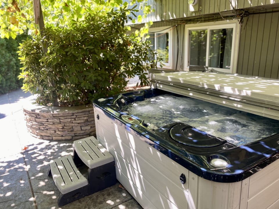 Hot tub that is under a natural canopy.