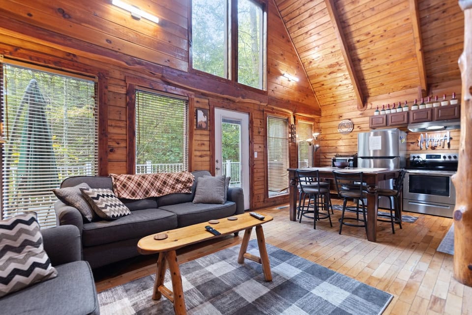 Cozy living room with vaulted ceilings and forest views