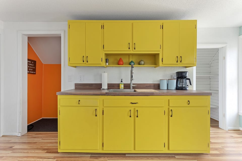 Sunny kitchen w/ yellow cabinets, coffee maker & plenty of counter space