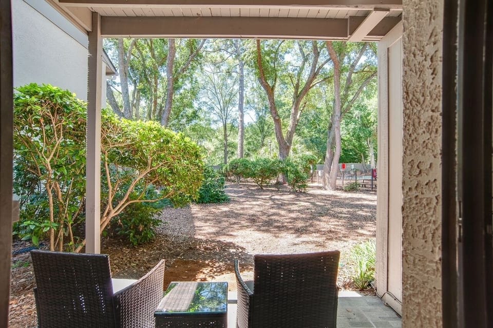Looking out from the sliding glass doors to the back yard area. Level. Pool. 