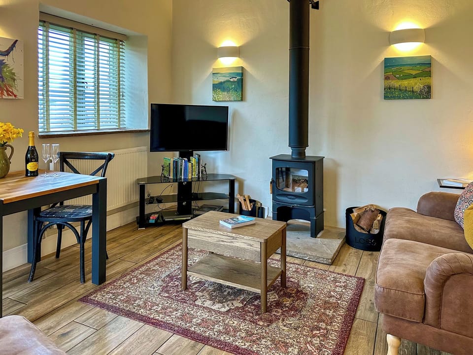 Stylishly furnished living area with cosy wood burner | Blakeskerra Barn, Kenfig, near Porthcawl