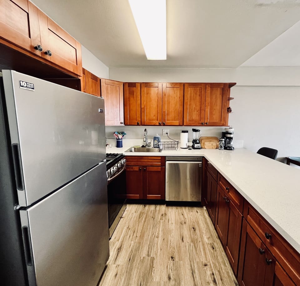 Kitchen with new stainless steel refrigerator, stove, and dishwasher.