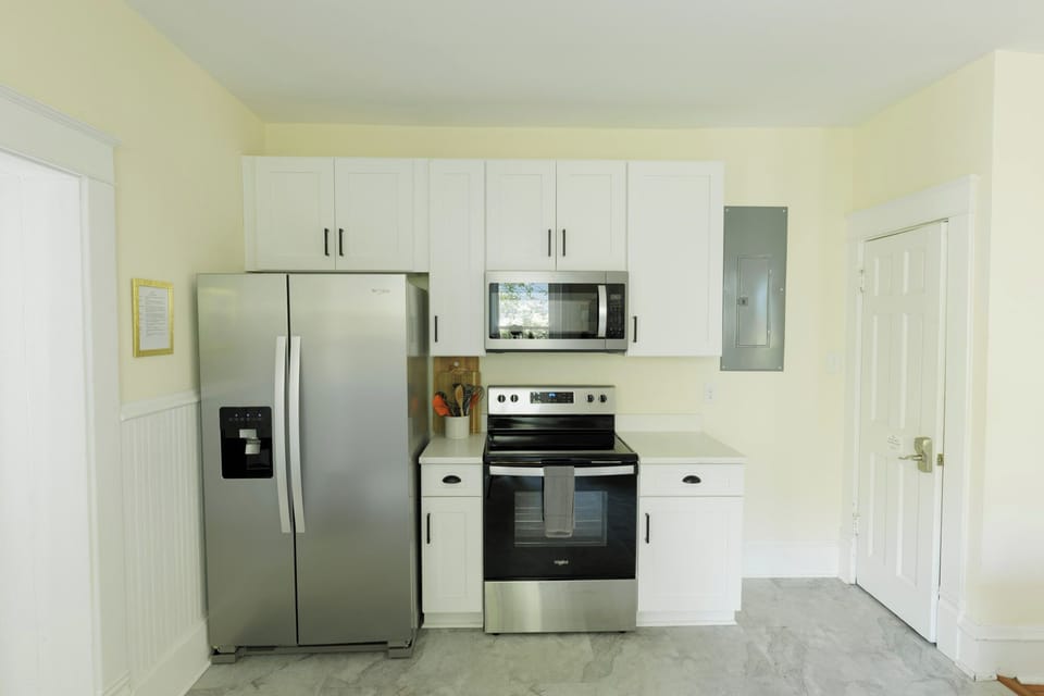 Stove, microwave, refrigerator, and cooking essentials.