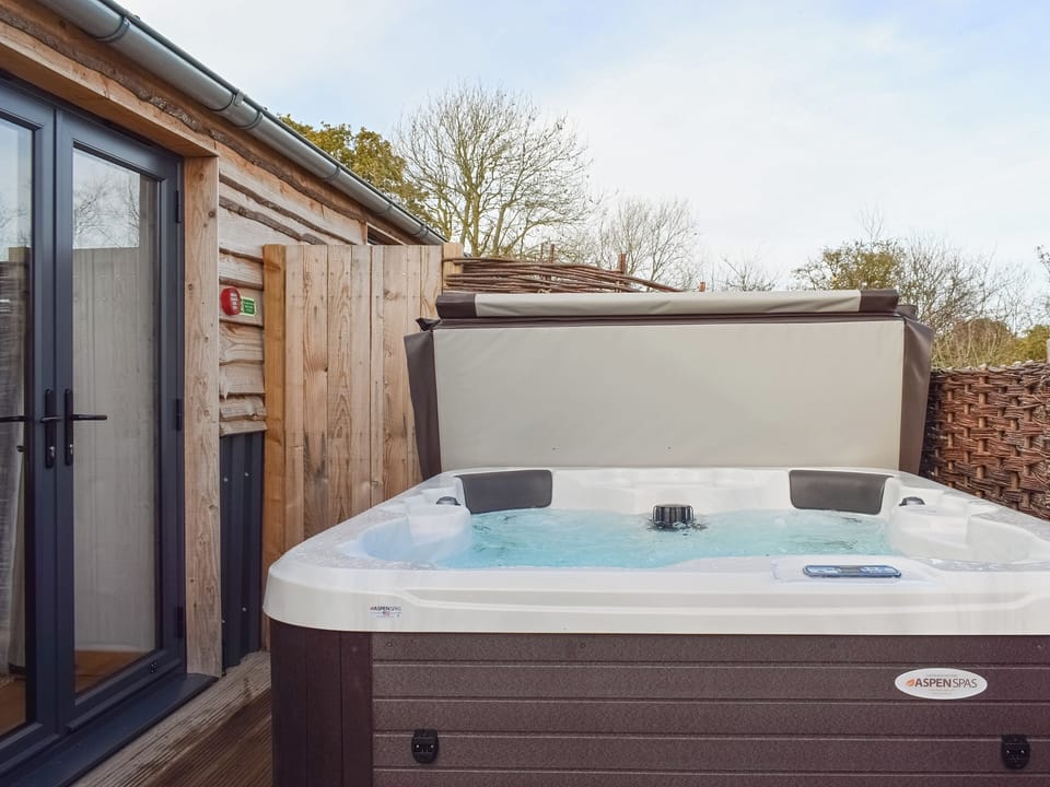 Luxurious hot tub within an enclosed patio area | Rondo - Rossiter&rsquo;s Vineyard Barn, Wellow, near Yarmouth