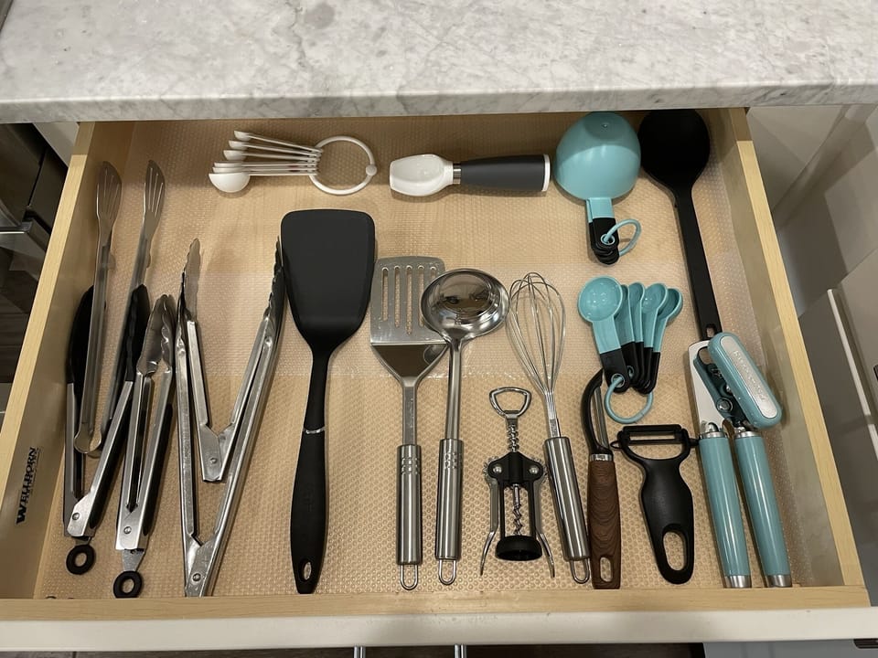 Stocked with kitchen tools, pots and pans.