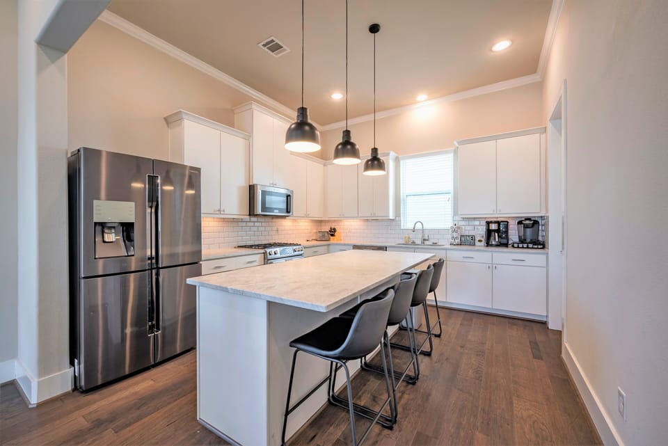 Fully stocked kitchen with stainless steel appliances and counter seating