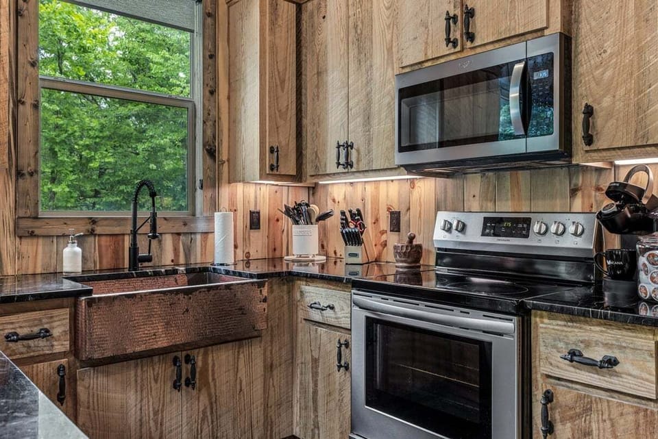 Kitchen includes a farmhouse sink, stove, microwave, fridge