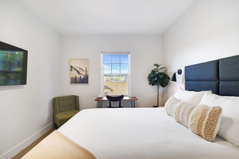 Suite 207 Queen size bed with mountain views and window with lots of natural light