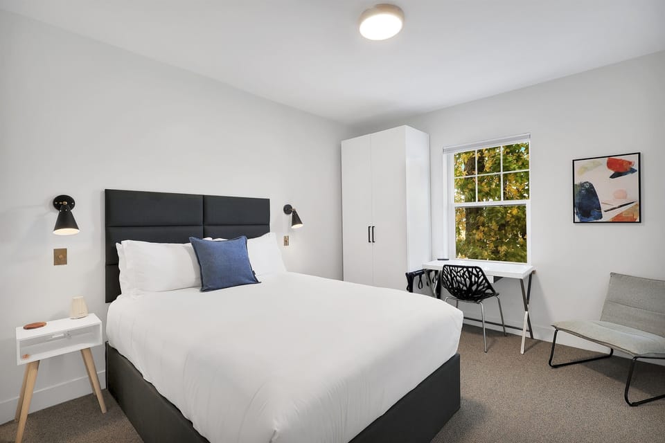 Queen sized bed in a bright private boutique hotel room