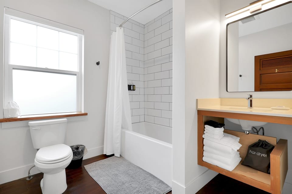 Deep modern bathtub, custom tile & stone countertops.