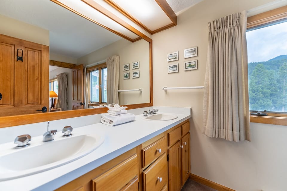 Freshen up in your spacious bathroom with dual sinks and stunning mountain views through every window.