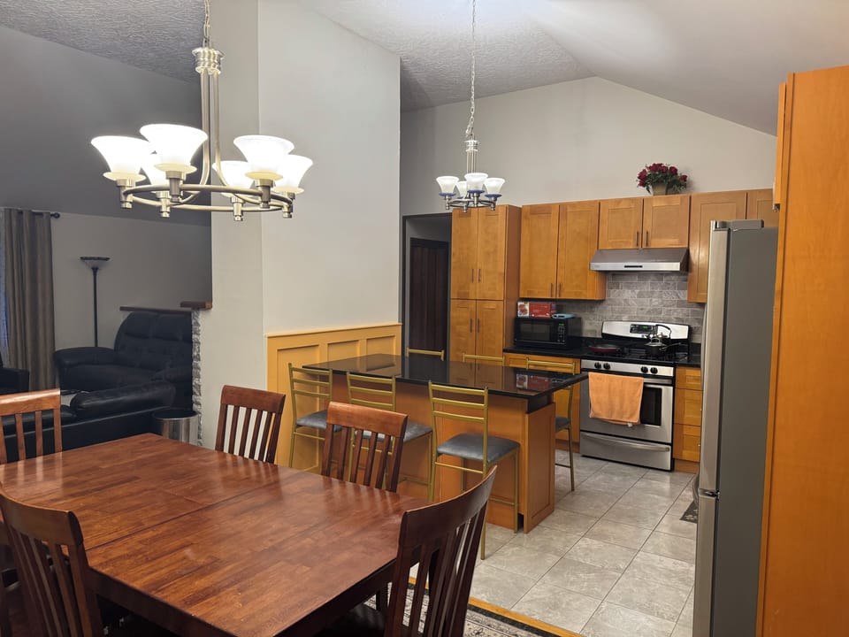 Family of 10-12  enjoy nice meal in kitchen countertop and  dining room table .