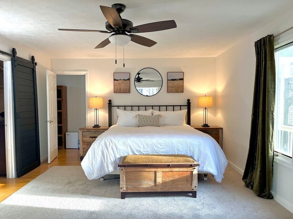 Primary bedroom is incredibly spacious and features a large walk-in closet, en suite full bathroom with glass-enclosed shower, and double vanity. Private screened-in porch has seating and provides beautiful overlook of the property.